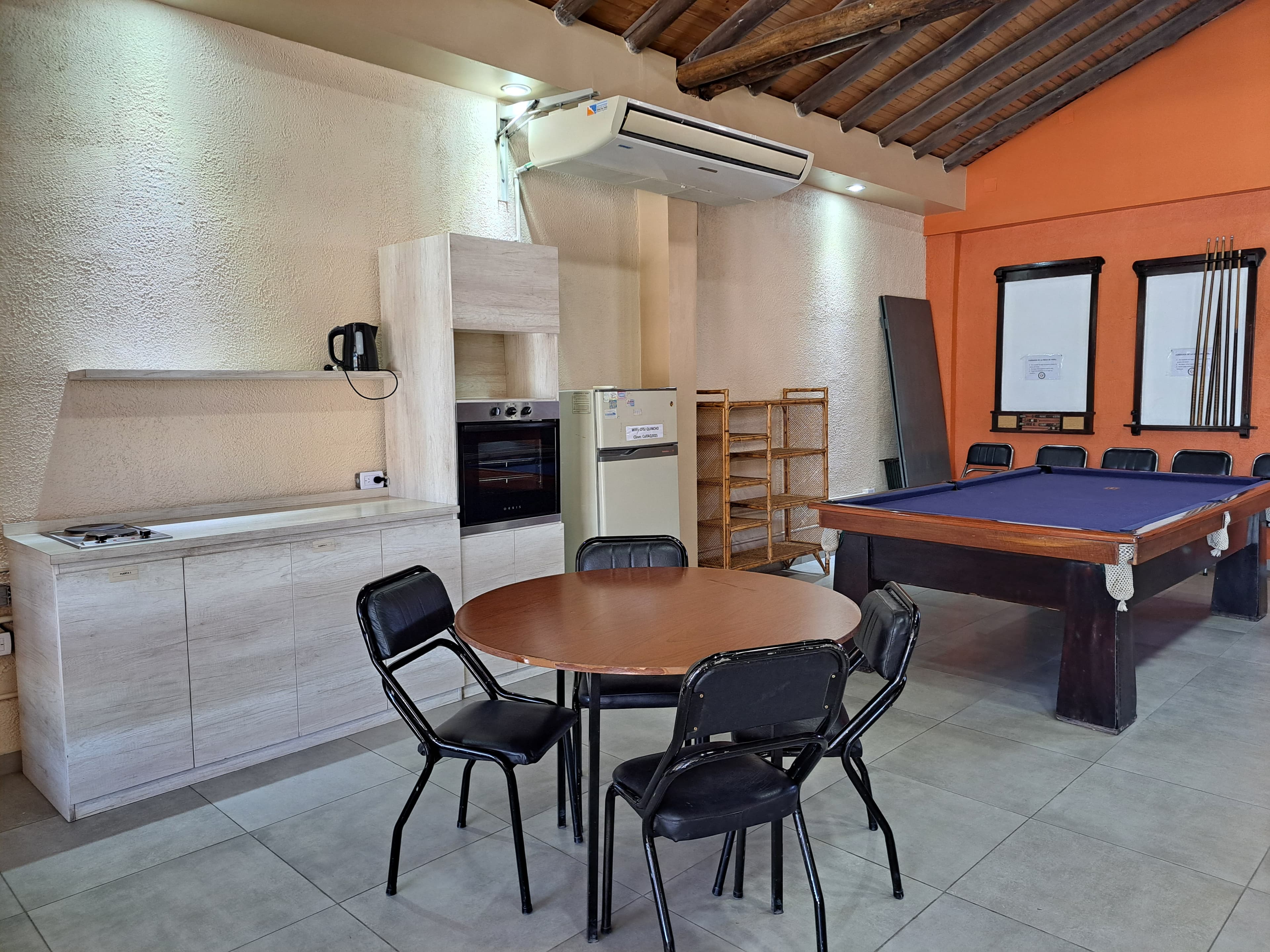 Sector del quincho con mesas y parrilla